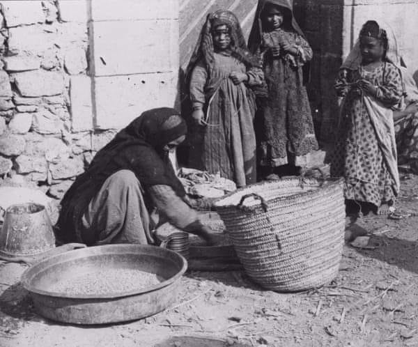 عرب المعادي في القاهرة تقوم بتجهيز القمح للطحين سنة 1912م