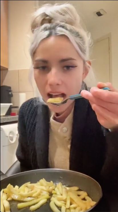 فتاة تاكل بطاطس بالزيت