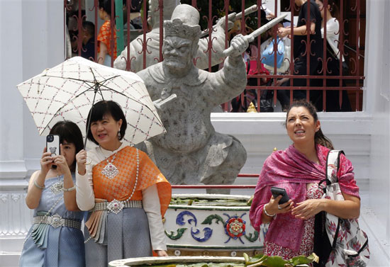 ياح-الذين-يرتدون-الأزياء-التايلاندية-التقليدية-يحمون-أنفسهم-من-أشعة-الشمس