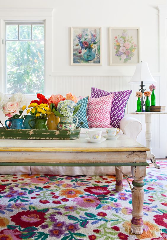 غرفة جلوس صيفية جريئة مع أعمال فنية زهرية وأزهار في مزهريات