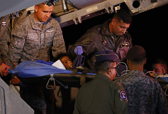 افراد وعسكريون يتجمعون خلال عملية تفريغ لأربعة أطفال فقدوا بعد تحطم طائرة (3)