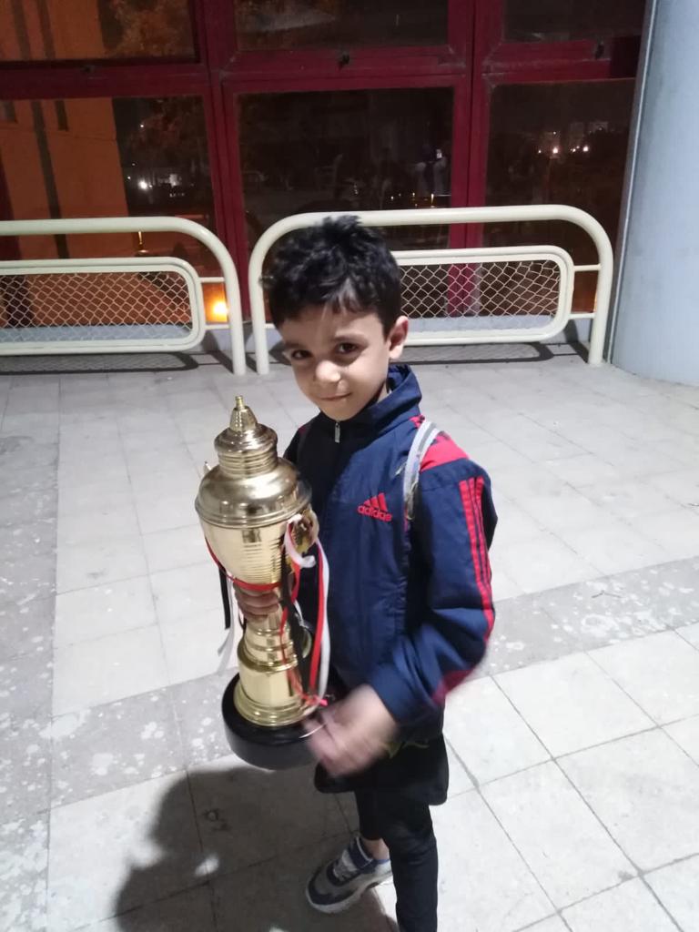 الطفل سليمان يحمل كأس البطولة