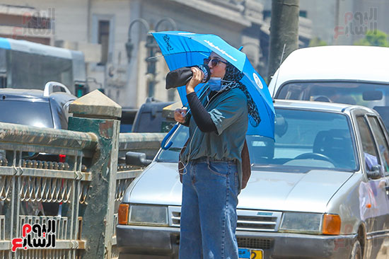 المواطنون يحملون الظلات للاحتماء من ارتفاع درجات الحراره  (2)