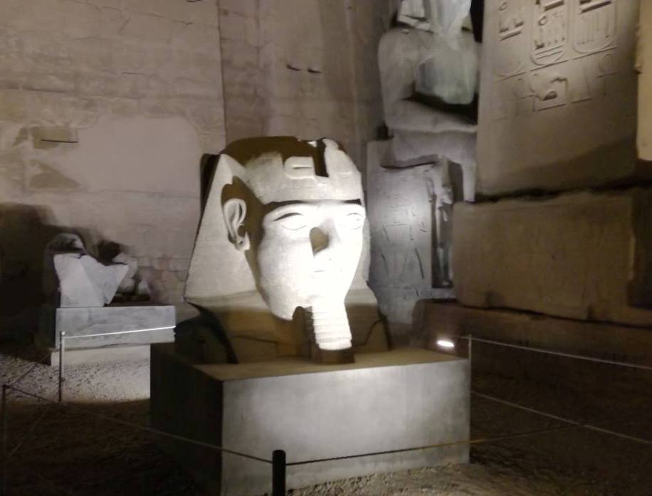 رأس أحد التماثيل قبل ترميمها بواجهة المعبد