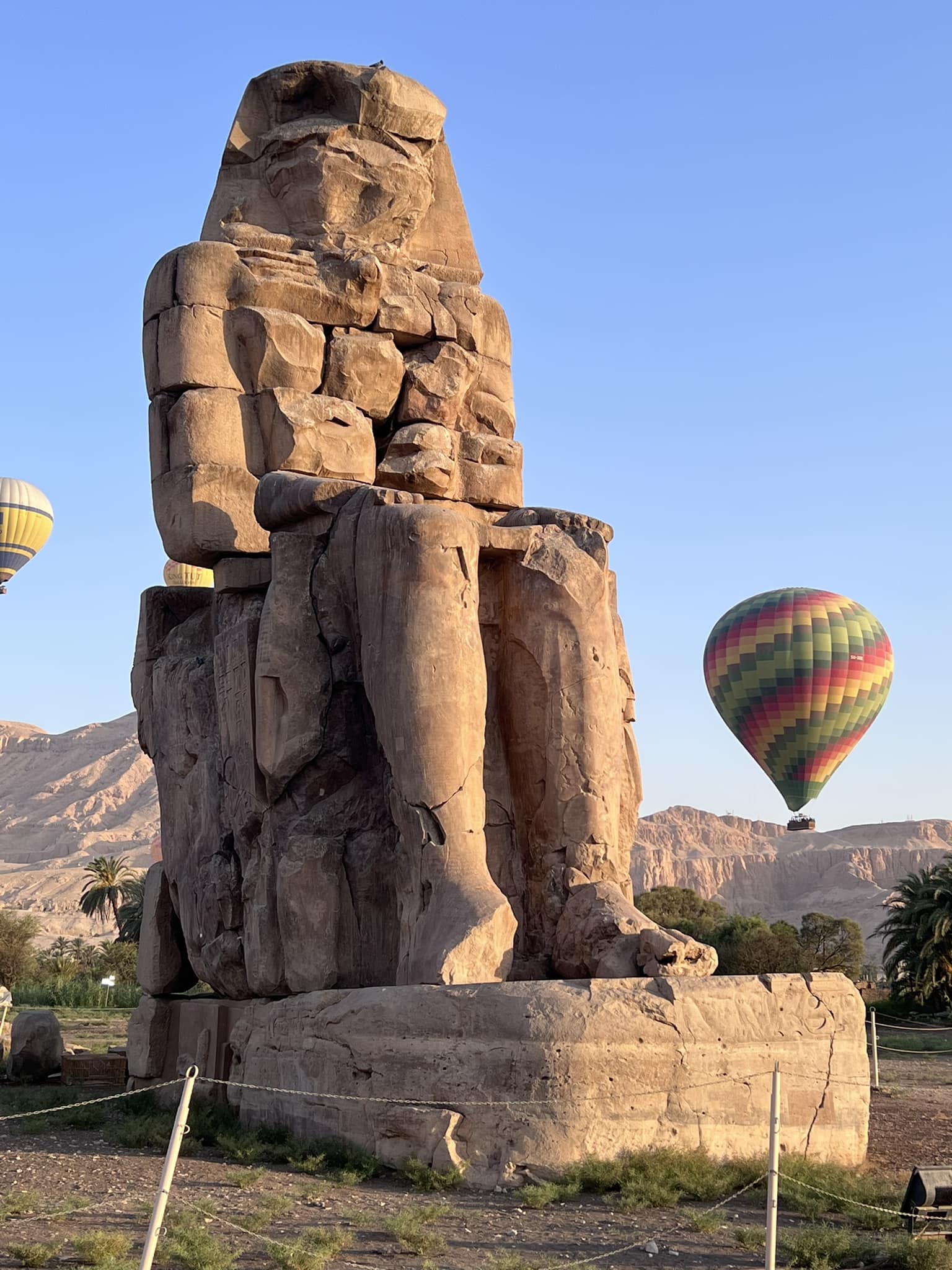 البالونات تحلق بين تمثالي ممنون