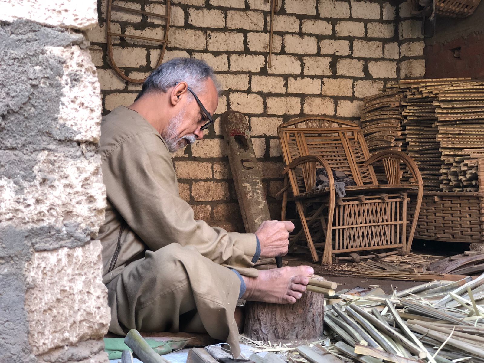 محمود بيومي يصنع منتجات الجريد في ورشته
