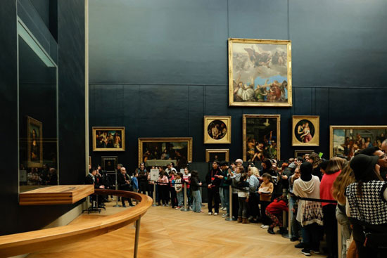 زوار يلتقطون الصور للوحة الموناليزا للرسام الإيطالي ليوناردو دافنشي