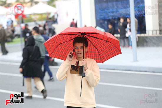 الأطفال يستخدمون  المظلات  للاحتماء من الأمطار  (1)