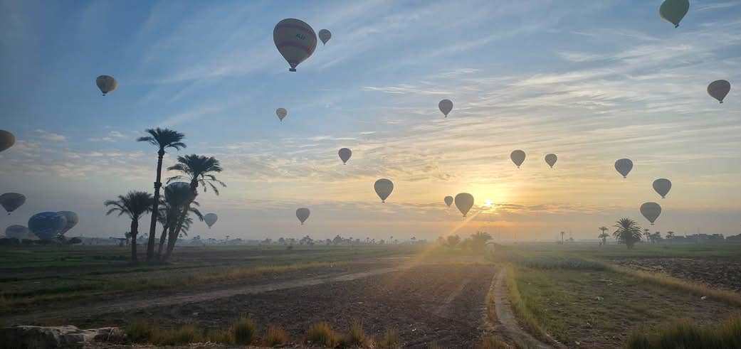 البالون الطائر يحلق فى سماء البر الغربي وبين الزراعات