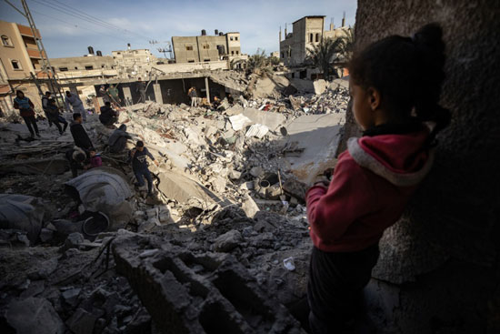 طفلة تشاهد منزلها المدمر نتيجة الغارات