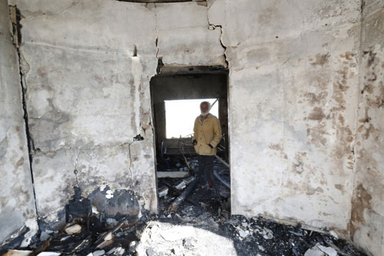 رجل فلسطيني يتفقد الأضرار داخل منزله