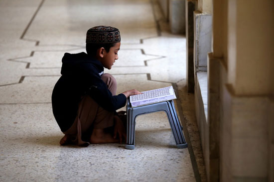 طفل يجلس فى المسجد ويحفظ القران