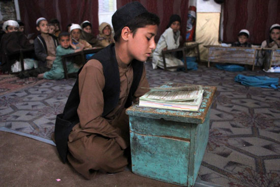 طفل يقراء القران الكريم من المصحف الشريف