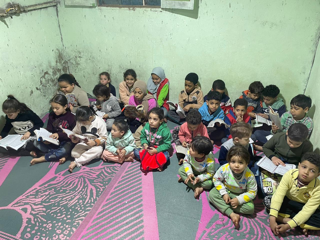عشرات الأطفال فى مراحل عمرية مختلفة يحفظون القرآن فى الكتاتيب
