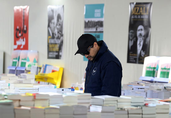 زائر يتفقد الكتب داخل المعرض