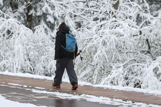 شخص يمشي أثناء تساقط الثلوج