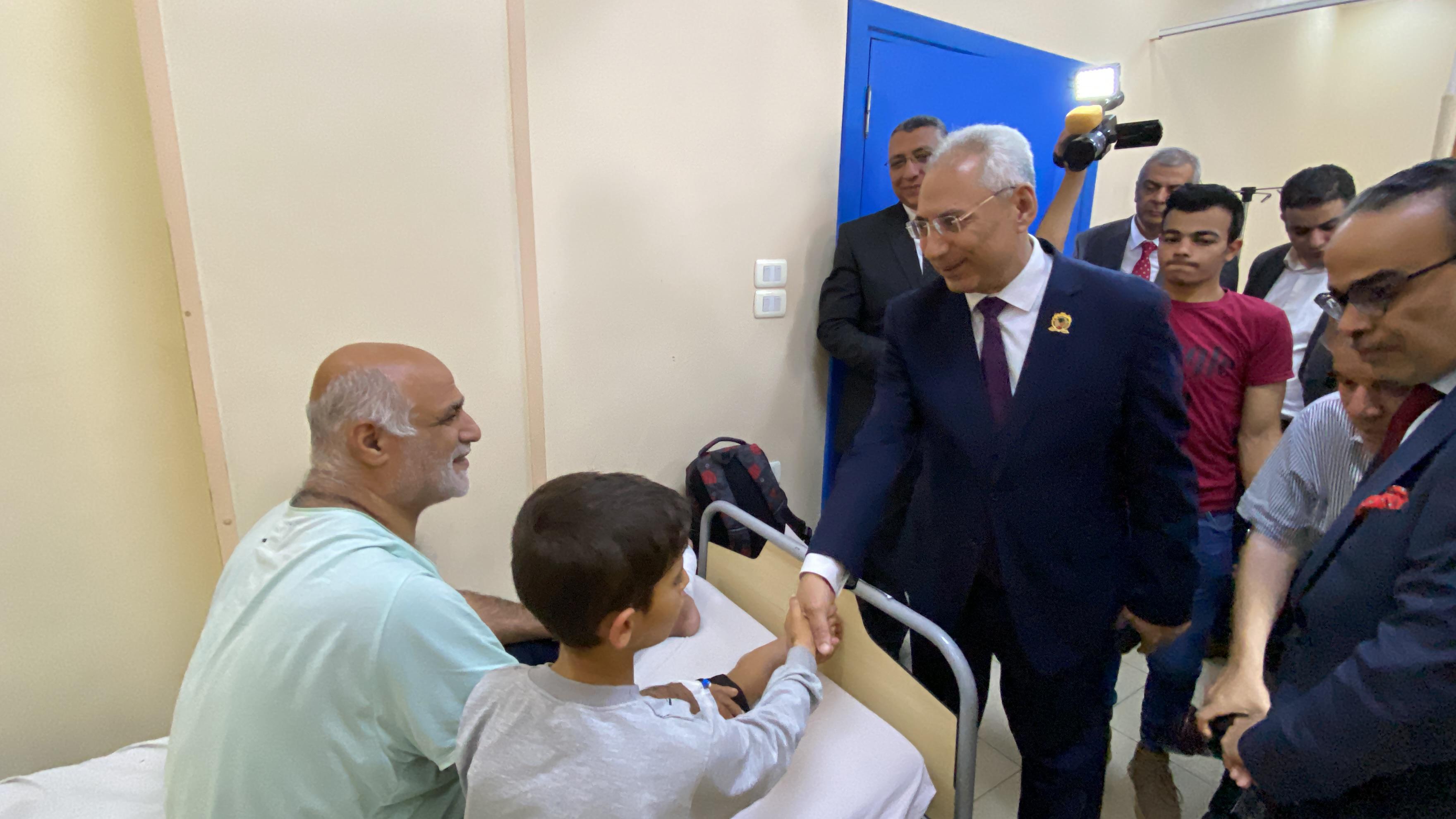 رئيس جامعة المنيا يصافح طفل مريض