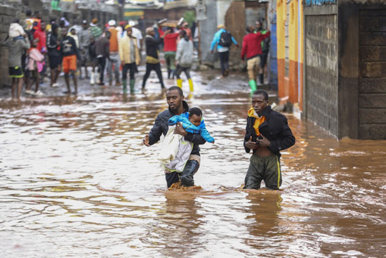 مواطنون يسيرون وسط مياه الأمطار والفيضانات