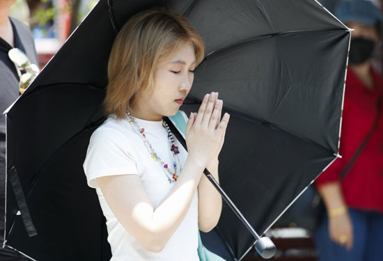 فتاة تستخدم المظلات ضد حرارة الشمس