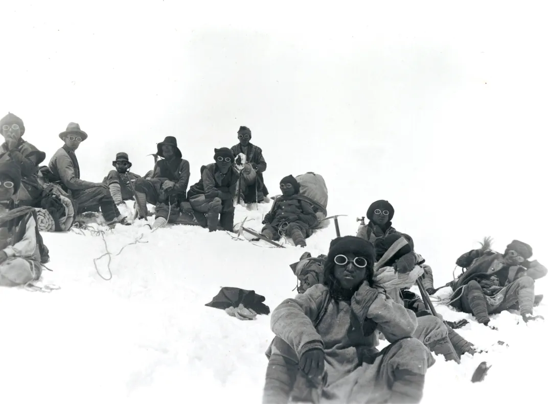 أعضاء بعثة جبل إيفرست عام 1922، بما في ذلك جورج مالوري وشيرباس، يستريحون أثناء صعود العقيد الشمالي