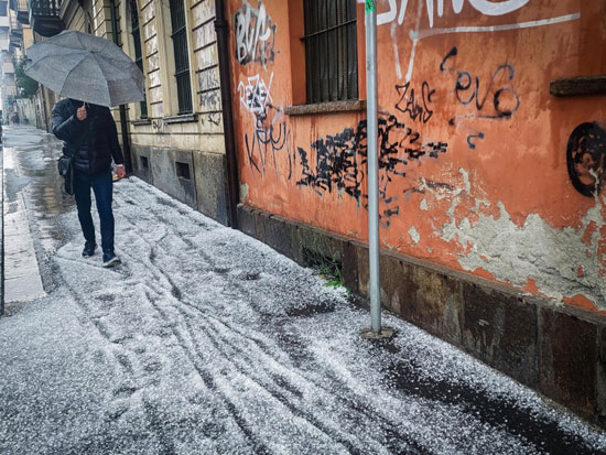 رجل يحتمى بالمظلة من الثلوج والأمطار