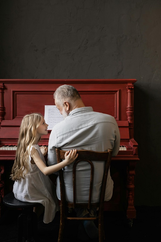 اب يعلم طفلته العزف على البيانو