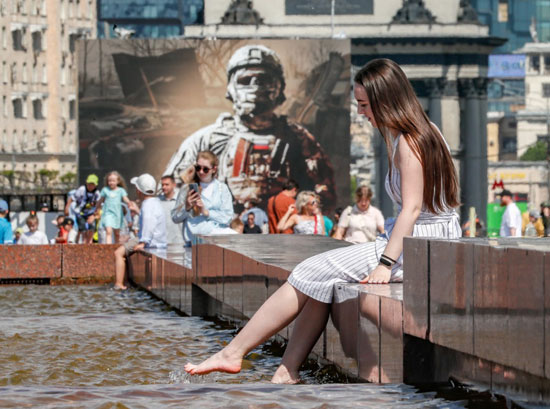 فتاة تجلس فى أحد نافورات المياه فى موسكو