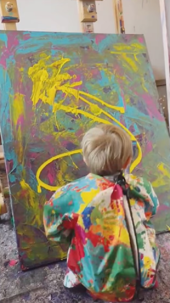 الطفل فى الاستديو يرسم إحدى لوحاته