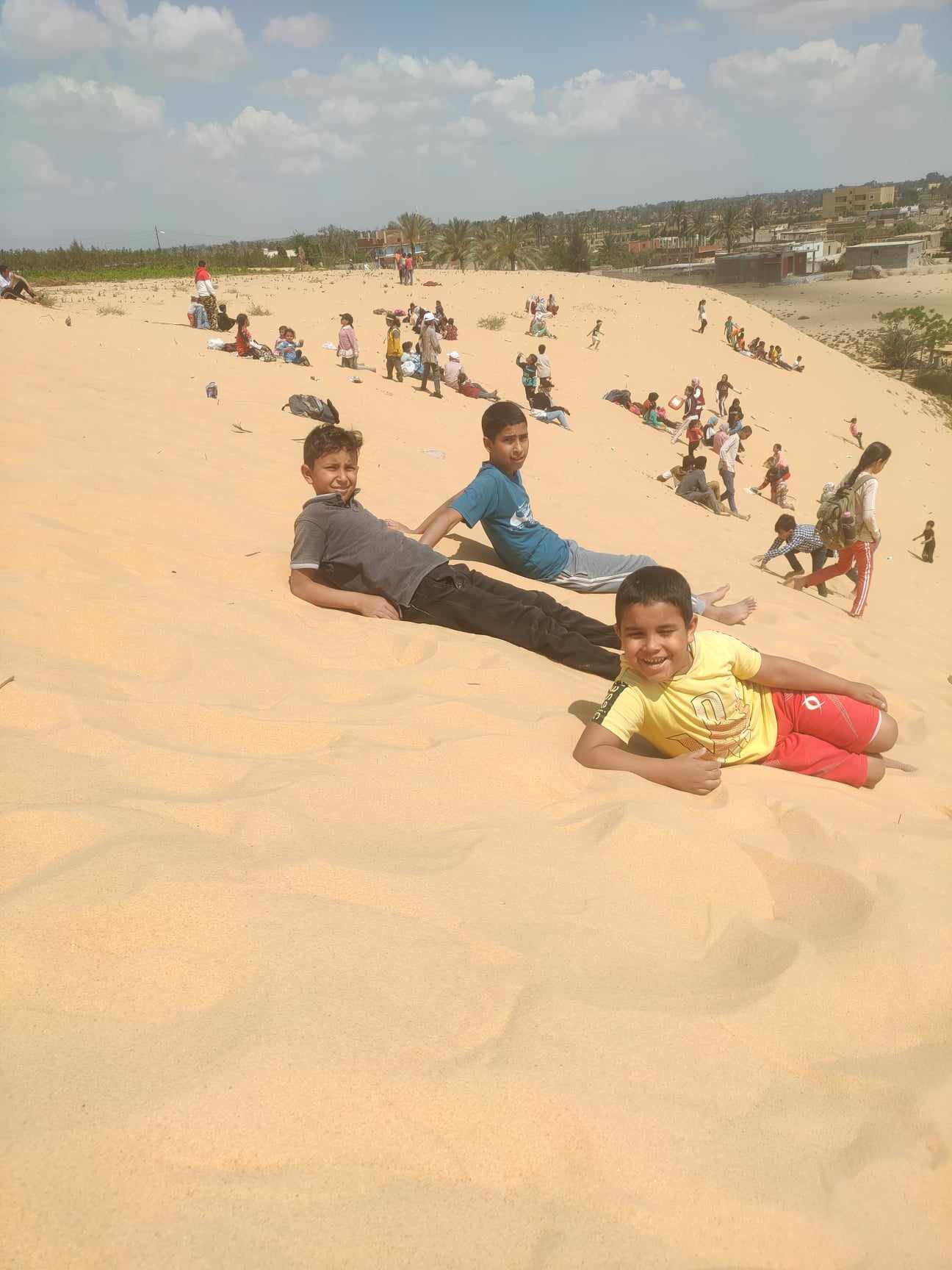 الأطفال يستمتعون بالتزحلق علي الرمال