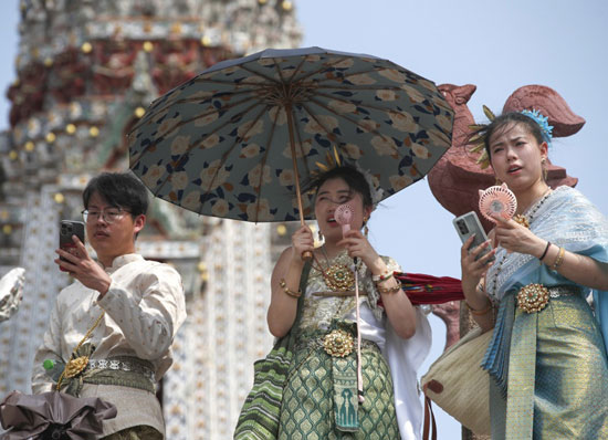 سياح صينيون يبردون أنفسهم بمراوح كهربائية محمولة