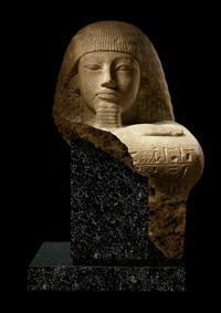 تمثال نادر في وضع القرفصاء يوجد على كتفه الأيسر نقش يتضمن إسم الجامعة القديمة (بر عنخ بر باست) من عهد الملك أمنوفيس الثاني