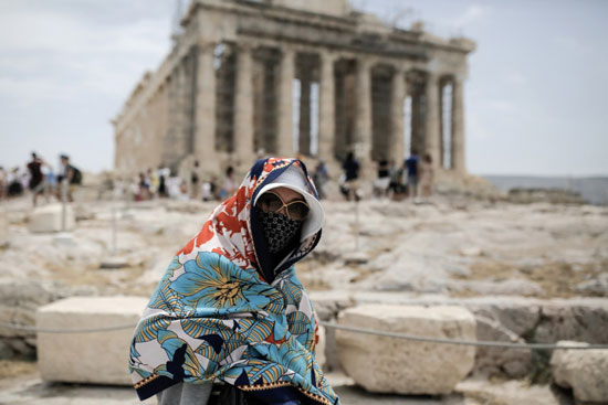 سياح يزورون الأكروبوليس وسط موجة حر في اليونان
