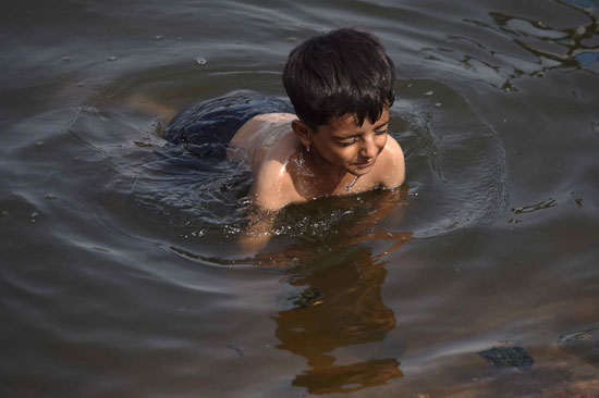 طفل يهرب الى المياه بعد ارتفاع درجات الحرارة