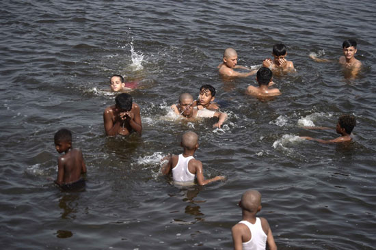 أشخاص يبردون أجسادهم في نهر
