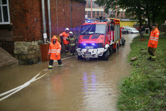 يعمل رجال الإطفاء على ضخ المياه من أحد العقارات المغمورة بالمياه