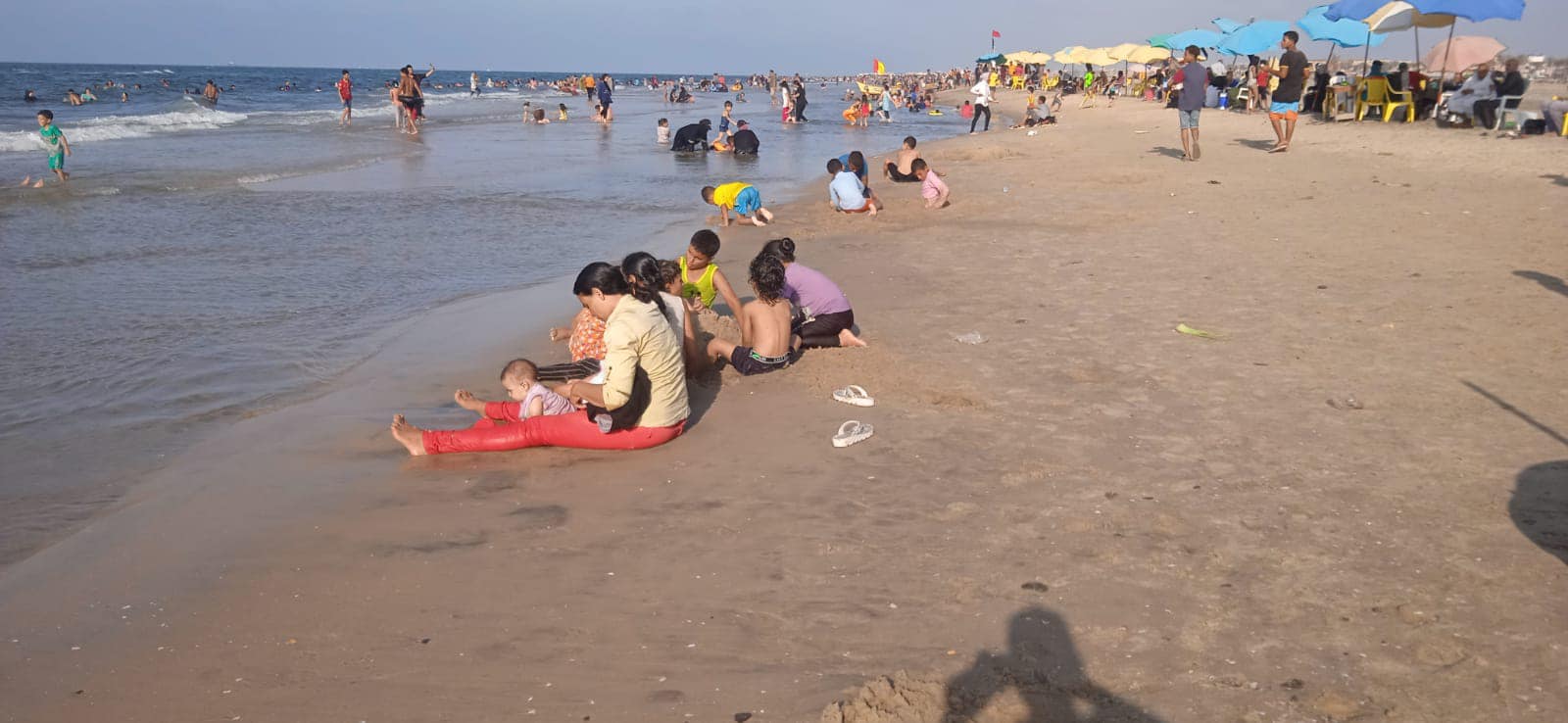 الاطفال يستمتعون باللعب بالرمال على شاطء مصيف بلطيم
