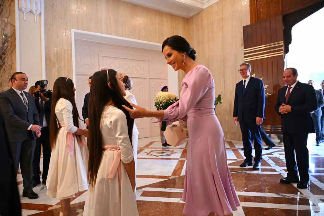 زوجة رئيس صربيا تداعب طفلة خلال استقبالها