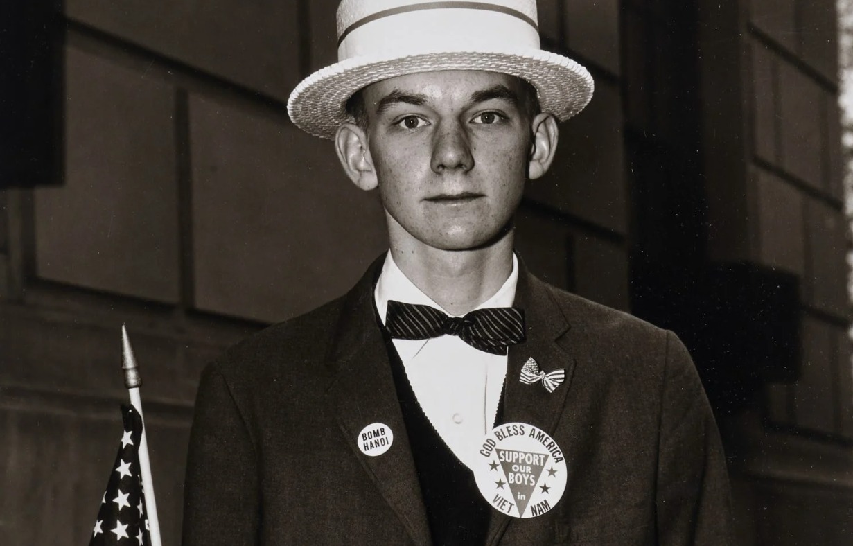 صورة للمصور ديان أربس، صبي يرتدي قبعة من القش وينتظر المشاركة في مسيرة مؤيدة للحرب، مدينة نيويورك، 1967