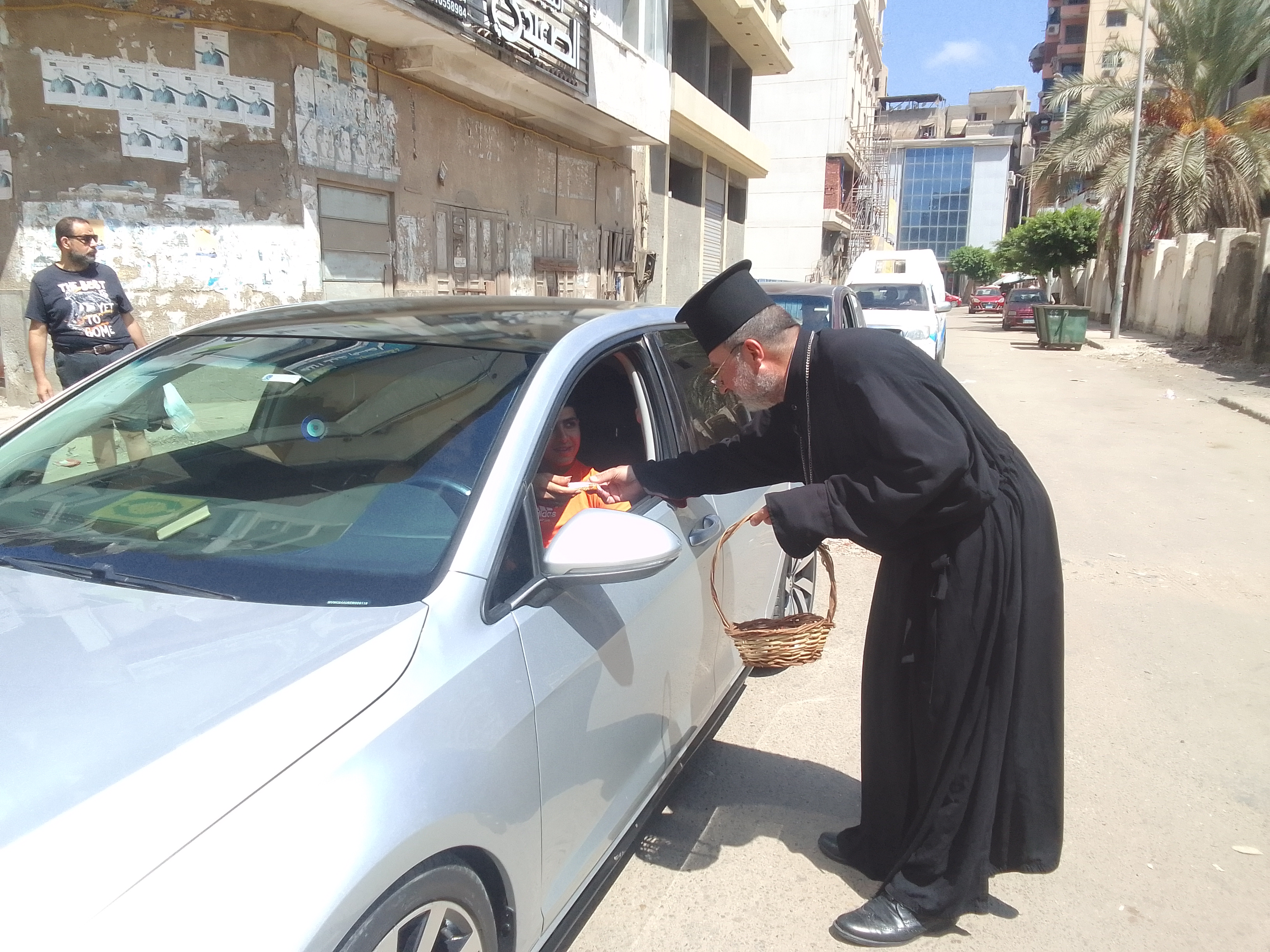 كاهن كنيسة يوزع حولي المولد النبوي الشريف بدمياط