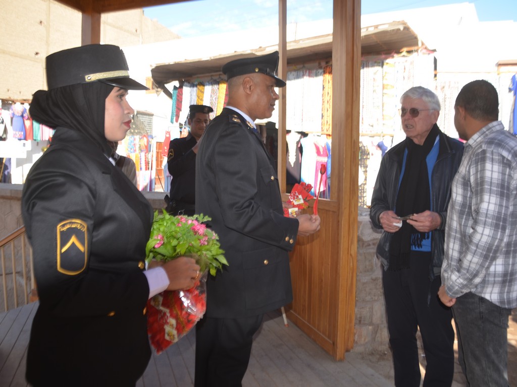الاحتفال بعيد الشرطة بتوزيع الهدايا والورود على السياح في معبد إسنا