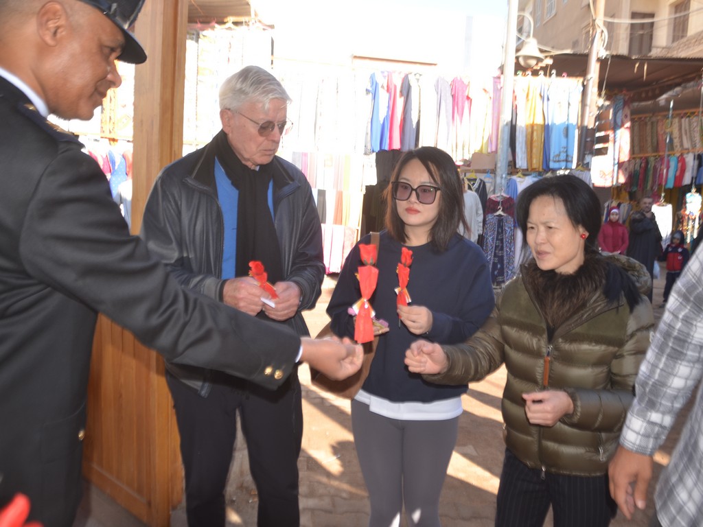 فرحة عيد الشرطة بتوزيع الهدايا والورود على السياح في معبد إسنا