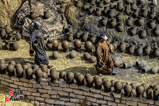السيدات يحملن الاواني الفخارية لحرقها في محرقة الفخار في الشرقية السيدات يحملن الاواني الفخارية لحرقها في محرقة الفخار في الشرقية