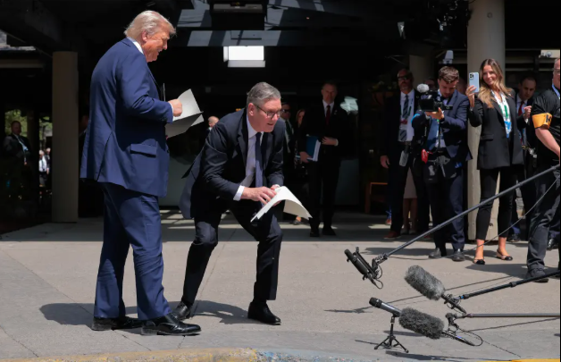 ستارمر يلتقط أوراق الاتفاقية من الأرض ستارمر يلتقط أوراق الاتفاقية من الأرض