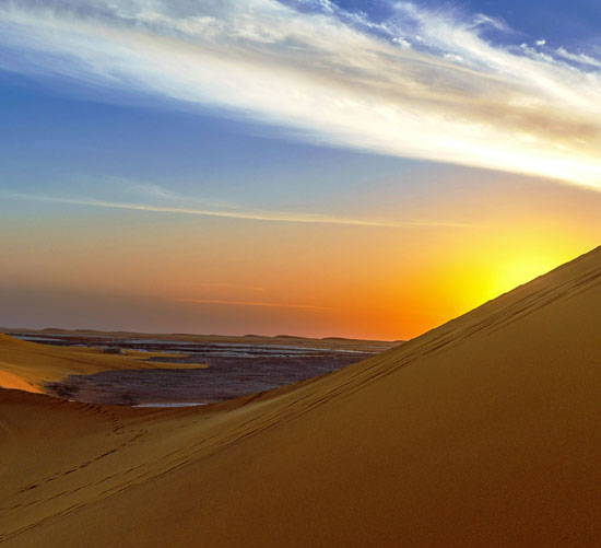 مشهد-شروق-الشمس-من-خلف-الكثبان-الرملية-