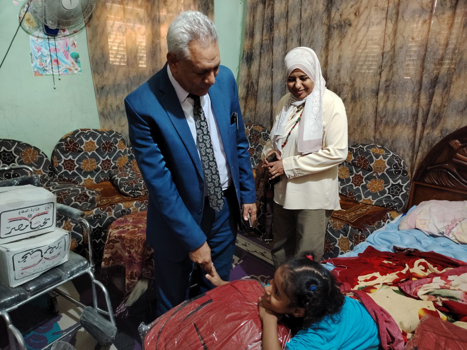 الطفلة تتسلم الحقيبة المدرسية 