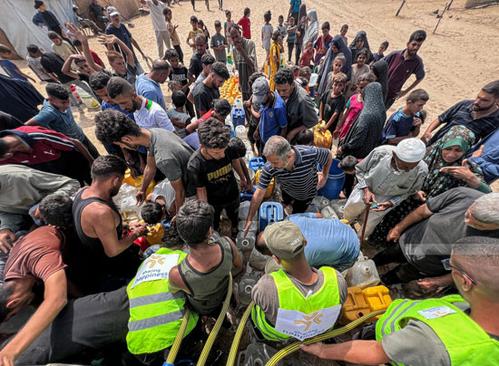 نازحون يتجمعون للحصول على مياه الشرب في مخيم النصيرات وسط قطاع غزة
