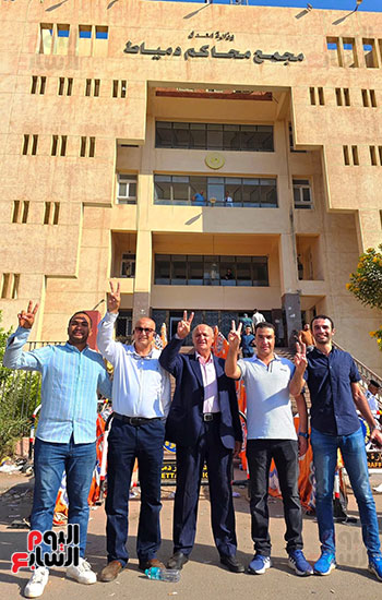 أنصار-احد-المرشحين-يرفعون-علامة-النصر-أمام-أبواب-المحكمة-بدمياط