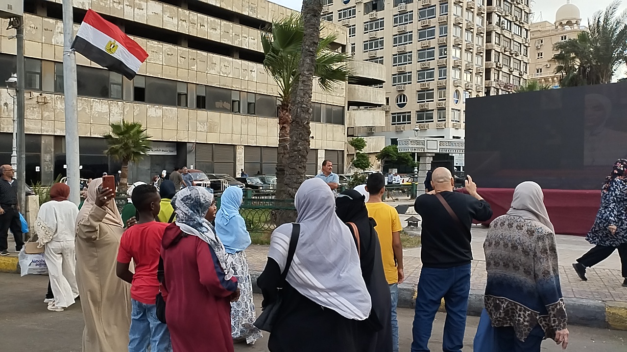 توافد أعداد من المواطنين أمام شاشات عرض افتتاح المتحف المصري بشوراع الإسكندرية