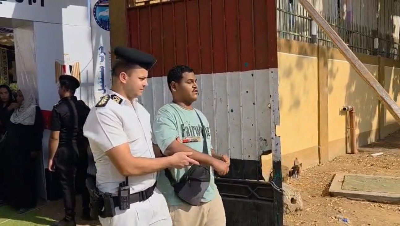 رجل شرطة يساعد كفيف على الادلاء بصوته فى انتخابات البرلمان