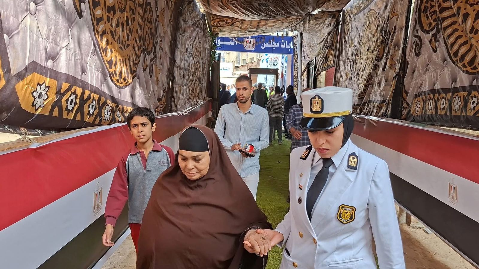 الشرطة النسائية تساعد السيدات كبار السن أمام اللجان الشرطة النسائية تساعد السيدات كبار السن أمام اللجان